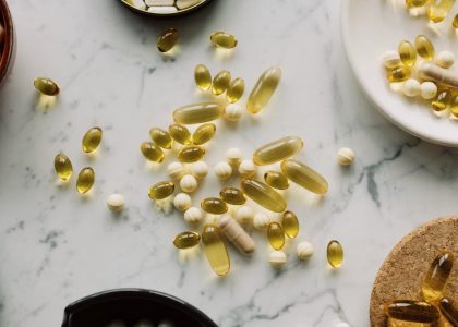 A top view of assorted capsules and pills displayed on a marble surface, showcasing a variety of medicines.